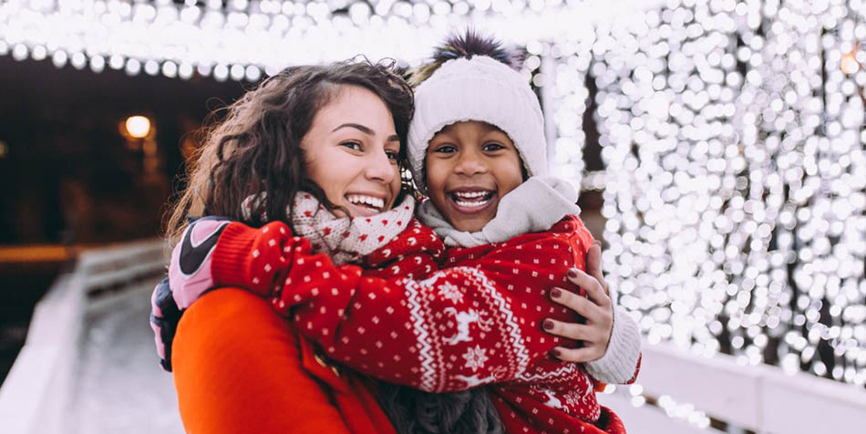 A young girl hugs her mother.